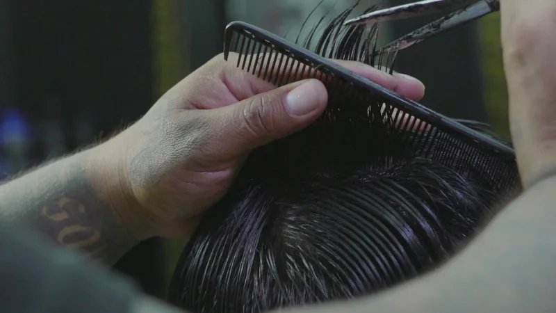 Tijera trabajando sobre el peine en un corte corto